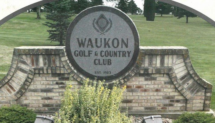 Brick entrance sign for Waukon Golf & Country Club in front of the fairway